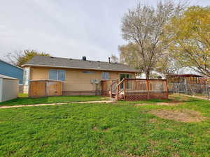 Back of house featuring a fenced backyard and a wooden deck