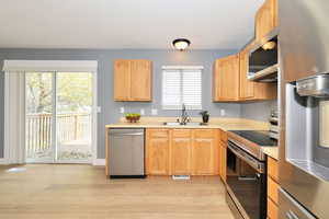 Kitchen featuring stainless steel appliances, light countertops, light wood-type flooring, and light brown cabinetry