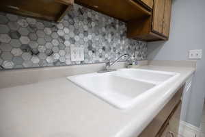 Kitchen view of light countertops and tasteful backsplash