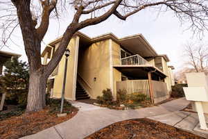 View of property exterior with stucco siding and stairway