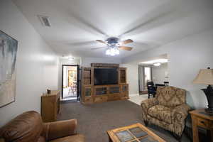 Living area with light colored carpet and a ceiling fan