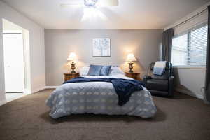 Carpeted bedroom featuring baseboards and a ceiling fan