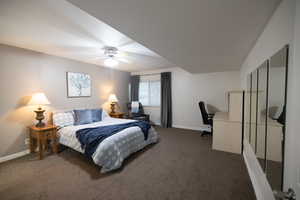 Carpeted bedroom with a ceiling fan and baseboards