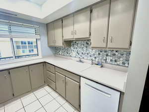 Kitchen view, newly painted taupe cabinets, and  tile floors