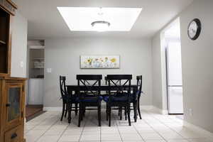 Dining space with washer / clothes dryer and light tile patterned flooring
