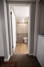 Full bath with a shower with curtain and light colored carpet