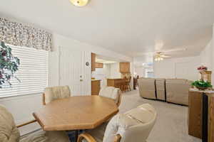 Dining room featuring light carpet and ceiling fan