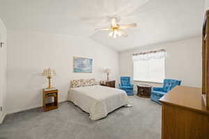 Bedroom featuring vaulted ceiling, light carpet, and ceiling fan