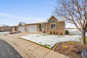 Ranch-style house featuring brick siding, concrete driveway, and an attached garage