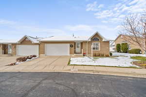 Ranch-style house with concrete driveway, brick siding, and an attached garage