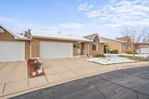 Ranch-style home with concrete driveway, brick siding, and an attached garage