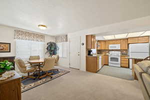 Dining room featuring light colored carpet and baseboards