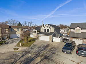 View of front facade featuring a residential view, driveway, stone siding, and a garage