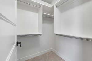 Walk in closet with light carpet