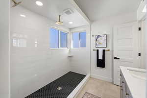 Master Bathroom featuring vanity, tiled shower, light tile patterned floors, and recessed lighting