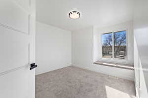 Unfurnished room with light colored carpet and baseboards
