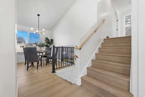 Stairway featuring wood finished floors and a chandelier