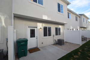 Rear view of house with stucco siding and a patio area