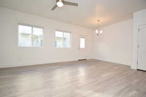 Foyer entrance with light wood finished floors, a chandelier, and a ceiling fan
