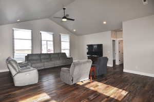Living room featuring dark wood finished floors, a ceiling fan, lofted ceiling, and recessed lighting