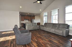 Living area with vaulted ceiling, dark wood-style flooring, ceiling fan, and recessed lighting