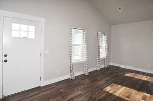 Foyer with dark wood-style floors and high vaulted ceiling