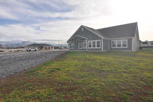 Back of house featuring a yard and a mountain view