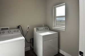 Laundry room with washer and dryer and dark wood-style flooring