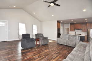 Living room featuring dark wood finished floors, recessed lighting, high vaulted ceiling, and ceiling fan