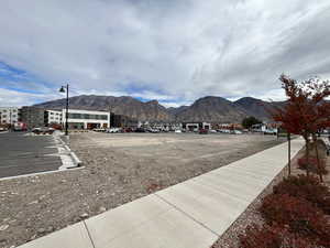 View of street featuring sidewalks, street lighting, and a mountain view