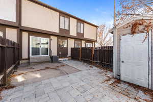 Back of property featuring a patio, stucco siding, a fenced backyard, and entry steps