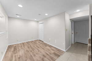 Spare room with light wood finished floors and recessed lighting