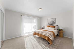 Bedroom with light colored carpet and baseboards