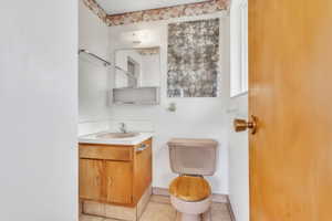 Half bathroom featuring vanity and light tile patterned floors