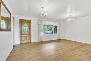 Foyer with a chandelier and light wood finished floors