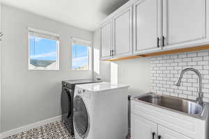 Washroom featuring cabinet space and washing machine and dryer