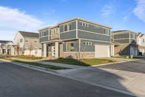 View of front of property featuring a residential view, driveway, and a garage