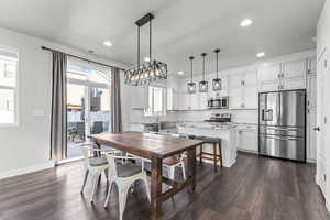 Dining room with dark wood-style flooring and recessed lighting
