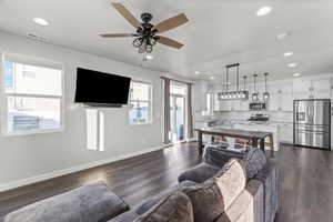 Living area with dark wood-style floors, a ceiling fan, and recessed lighting