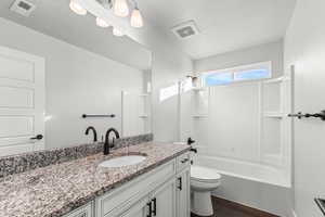Bathroom with shower / washtub combination, vanity, dark wood finished floors, and a textured ceiling