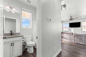 Bathroom with vanity, dark wood-style flooring, ceiling fan, and recessed lighting