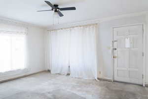 Family room with ceiling fan and large windows