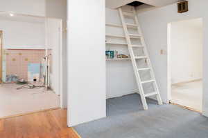 View from kitchen area showing storage shelves, and ladder to attic that could be used as a bonus room.