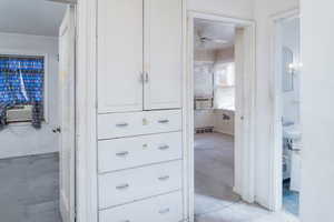 Hallway featuring built in linen closet and drawers.
