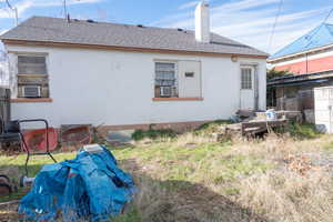 Rear view of the home featuring newer roof with shingles