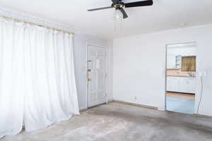 Family room with ceiling fan and large windows