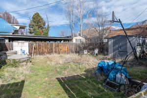 Fenced backyard featuring a tool shed and storage shed and a mountain view