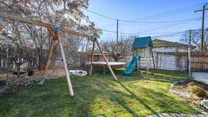 View of play area featuring a fenced backyard and a trampoline