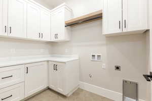 Laundry room featuring hookup for a washing machine, light tile patterned floors, gas dryer hookup, electric dryer hookup, and cabinet space
