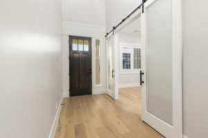 Entryway featuring a barn door and light wood-type flooring